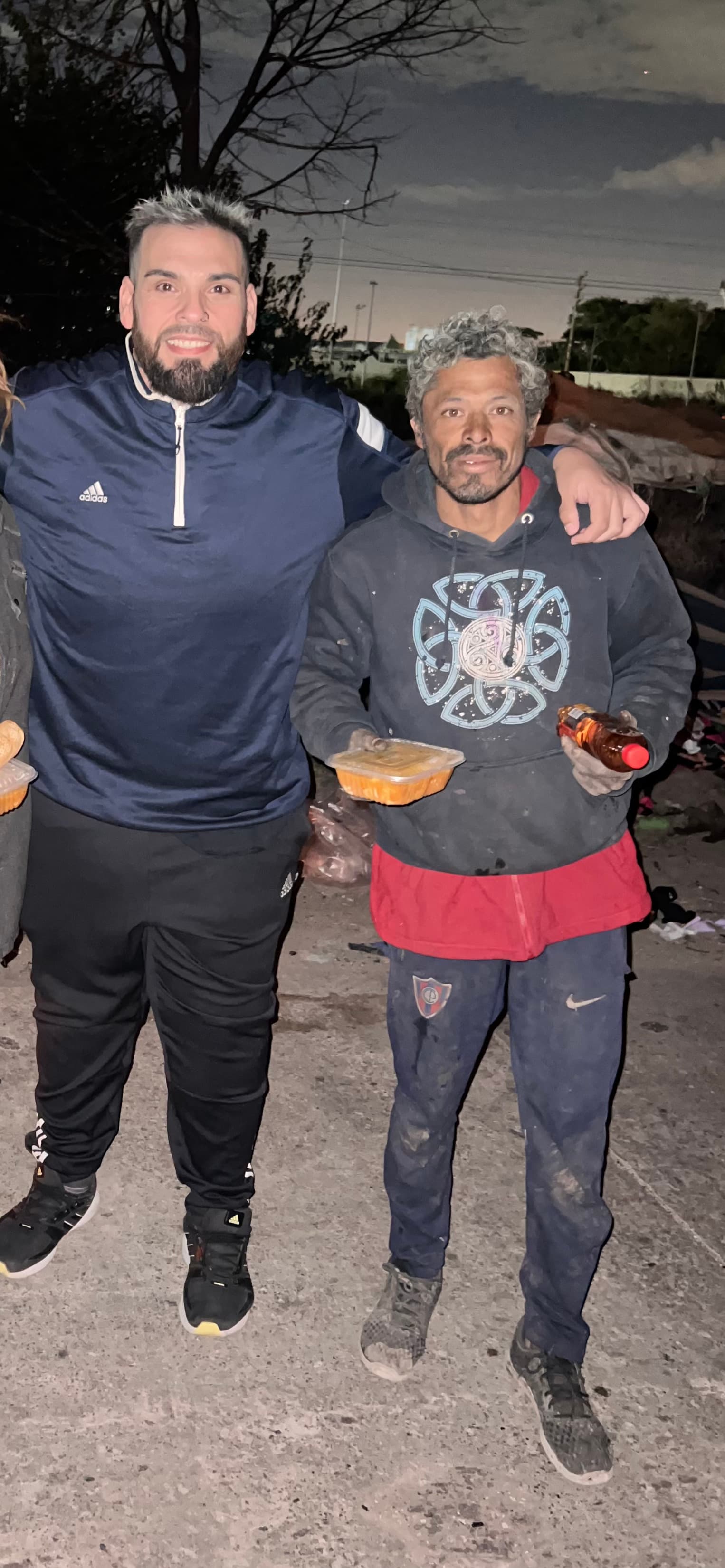 Entrega de una vianda de comida a una persona en situación de calle, de noche