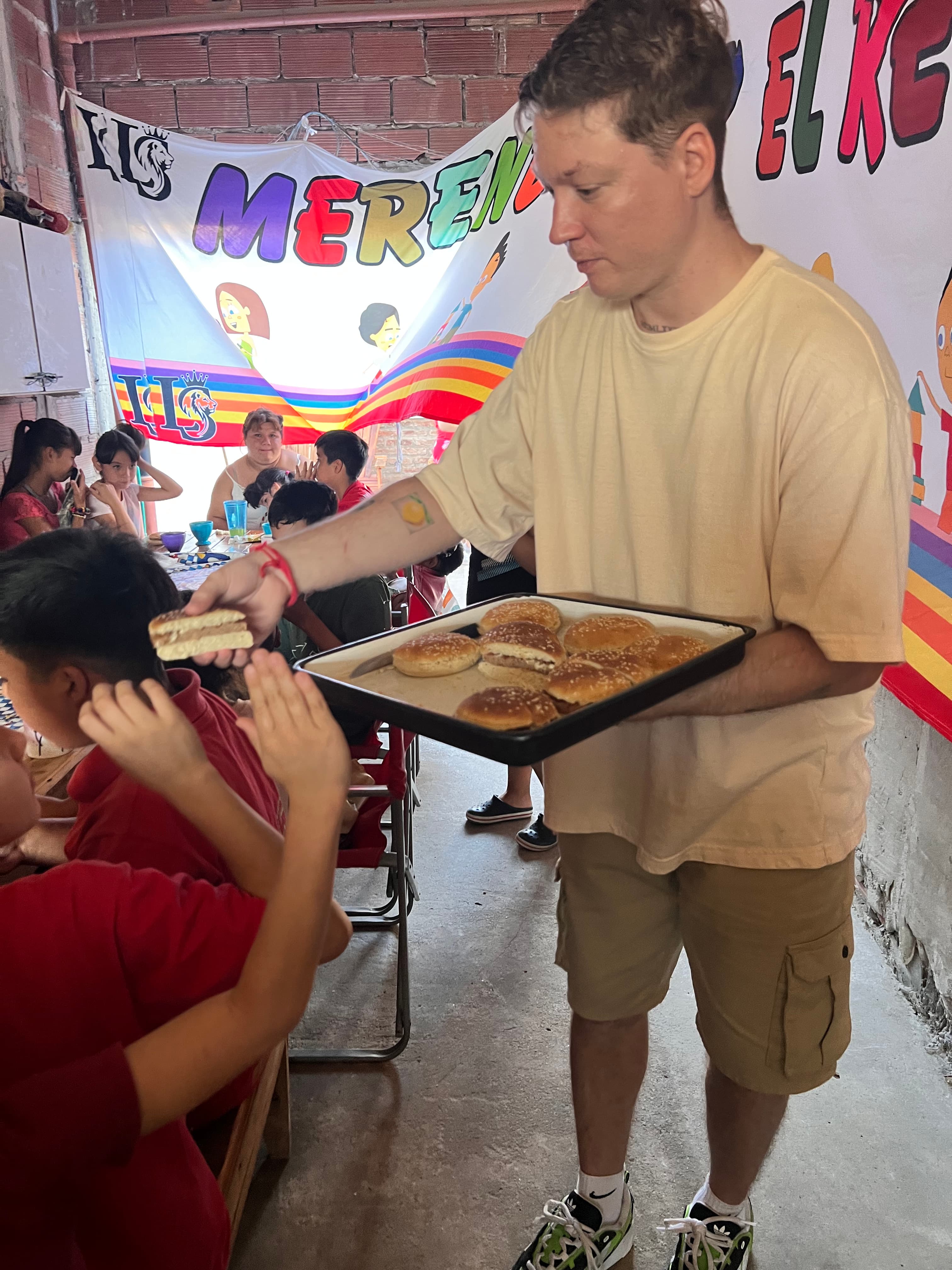 Entrega de hamburguesas a los chicos en el merendero