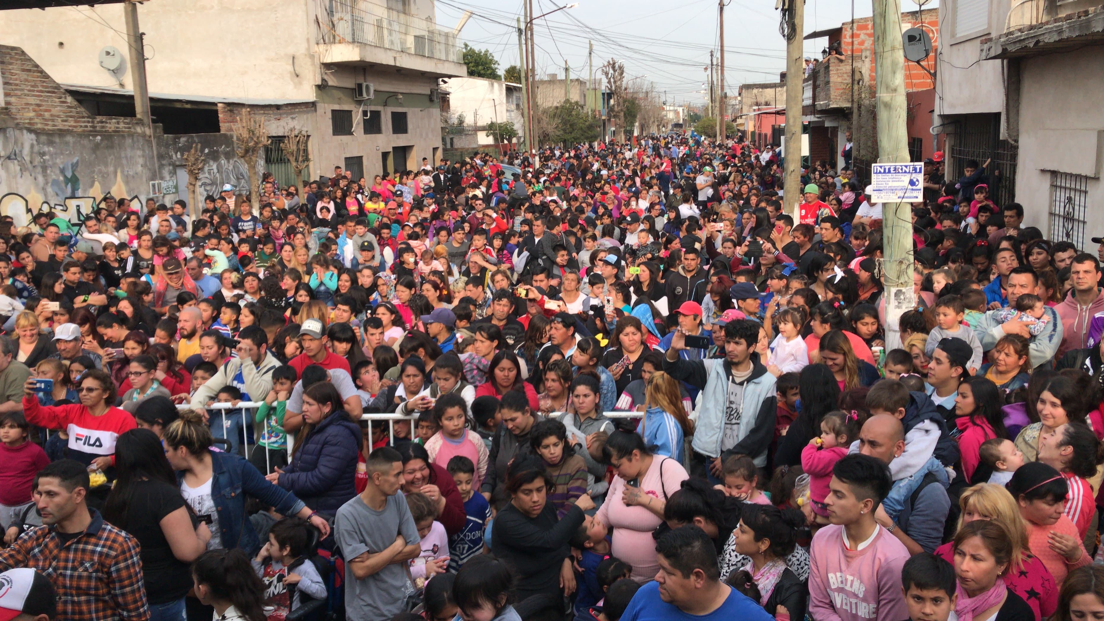Multitud llenando una calle del barrio para festejar el Día del Niño