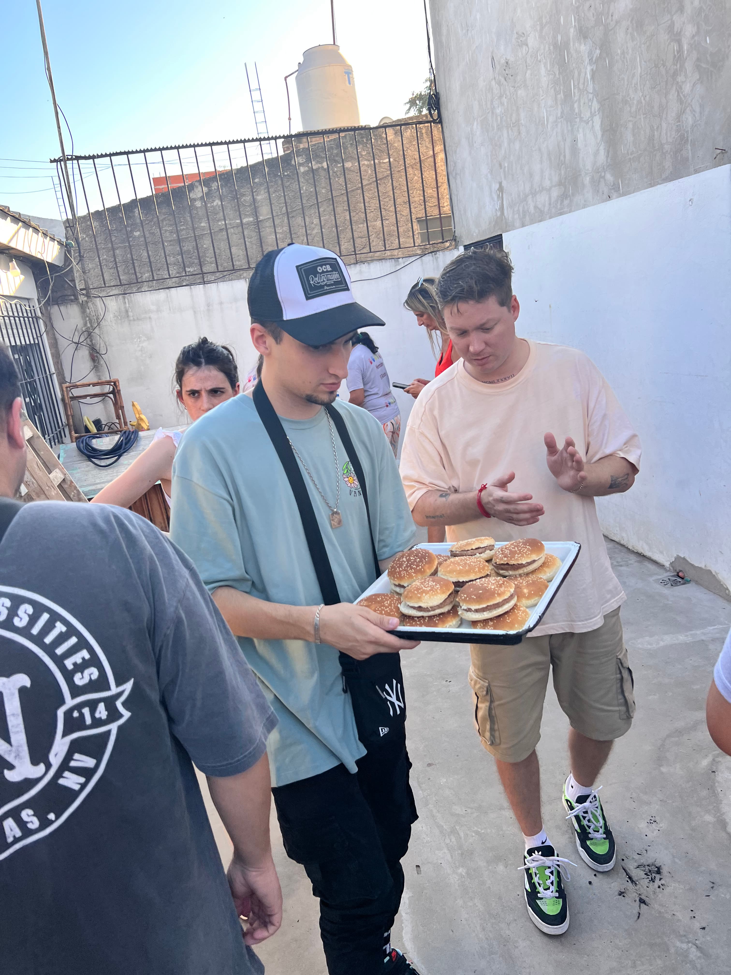 Voluntarios armando los panes con hamburguesas para el merendero