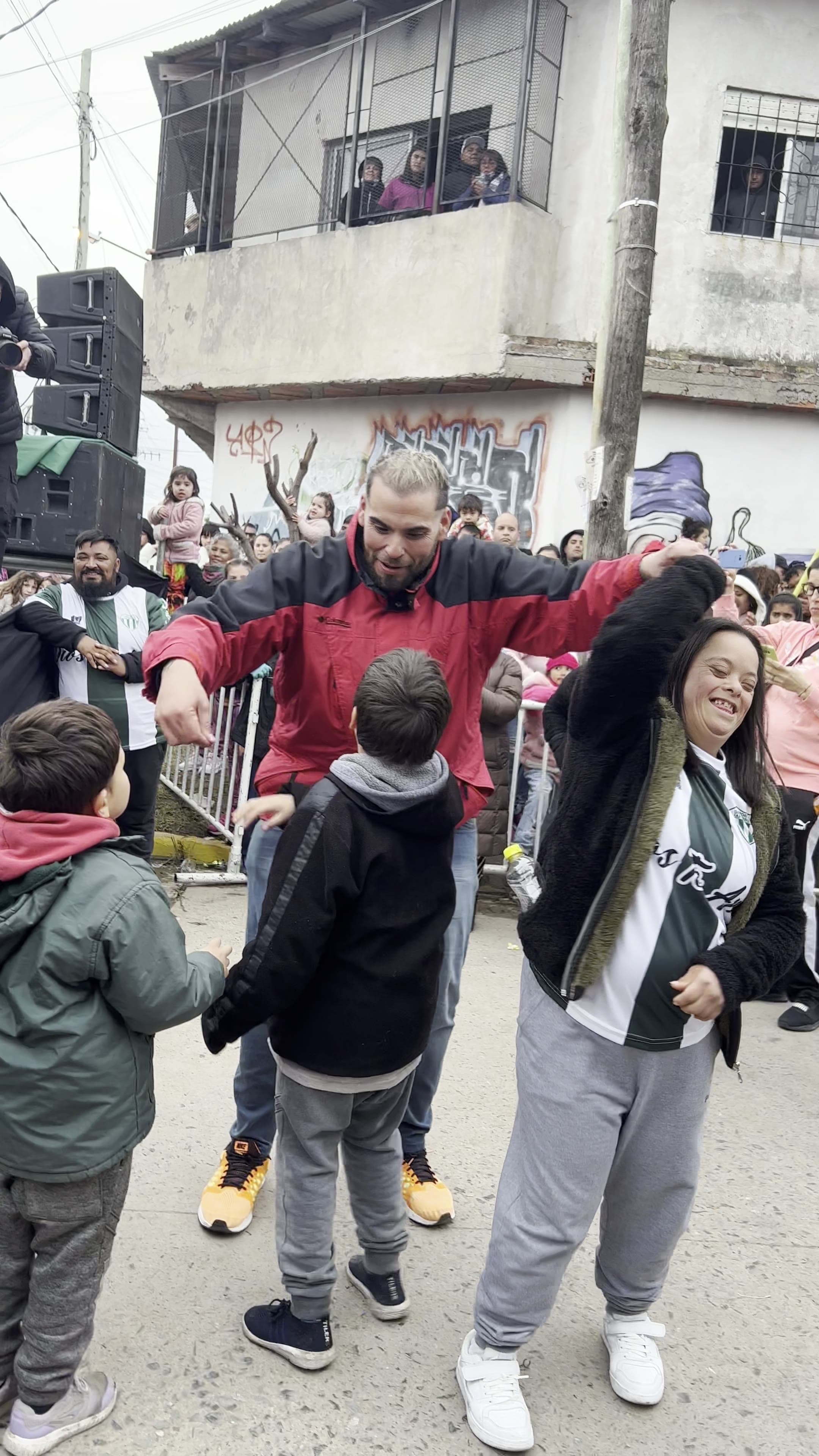 Multitud llenando una calle del barrio para festejar el Día del Niño