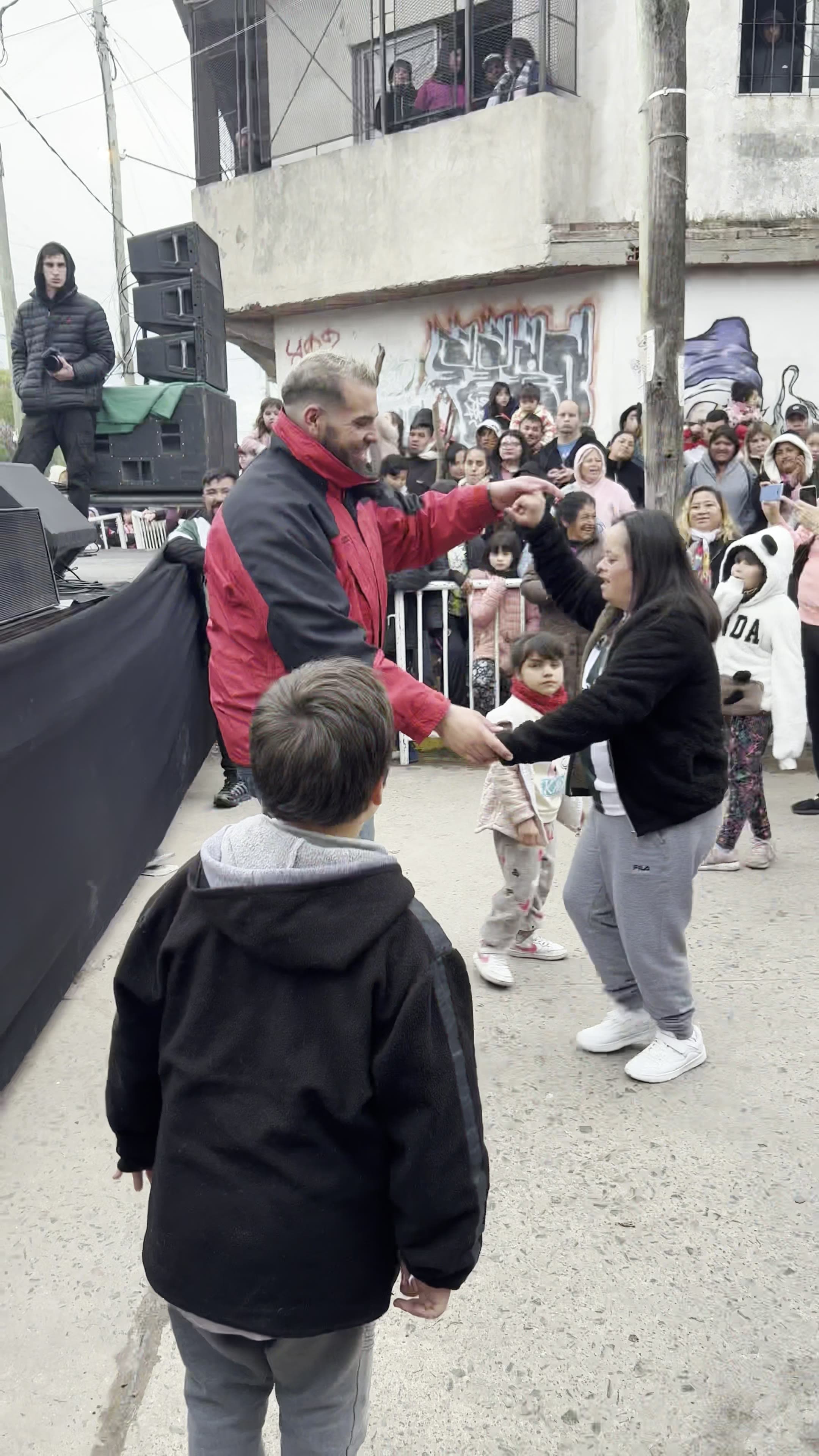 Multitud llenando una calle del barrio para festejar el Día del Niño